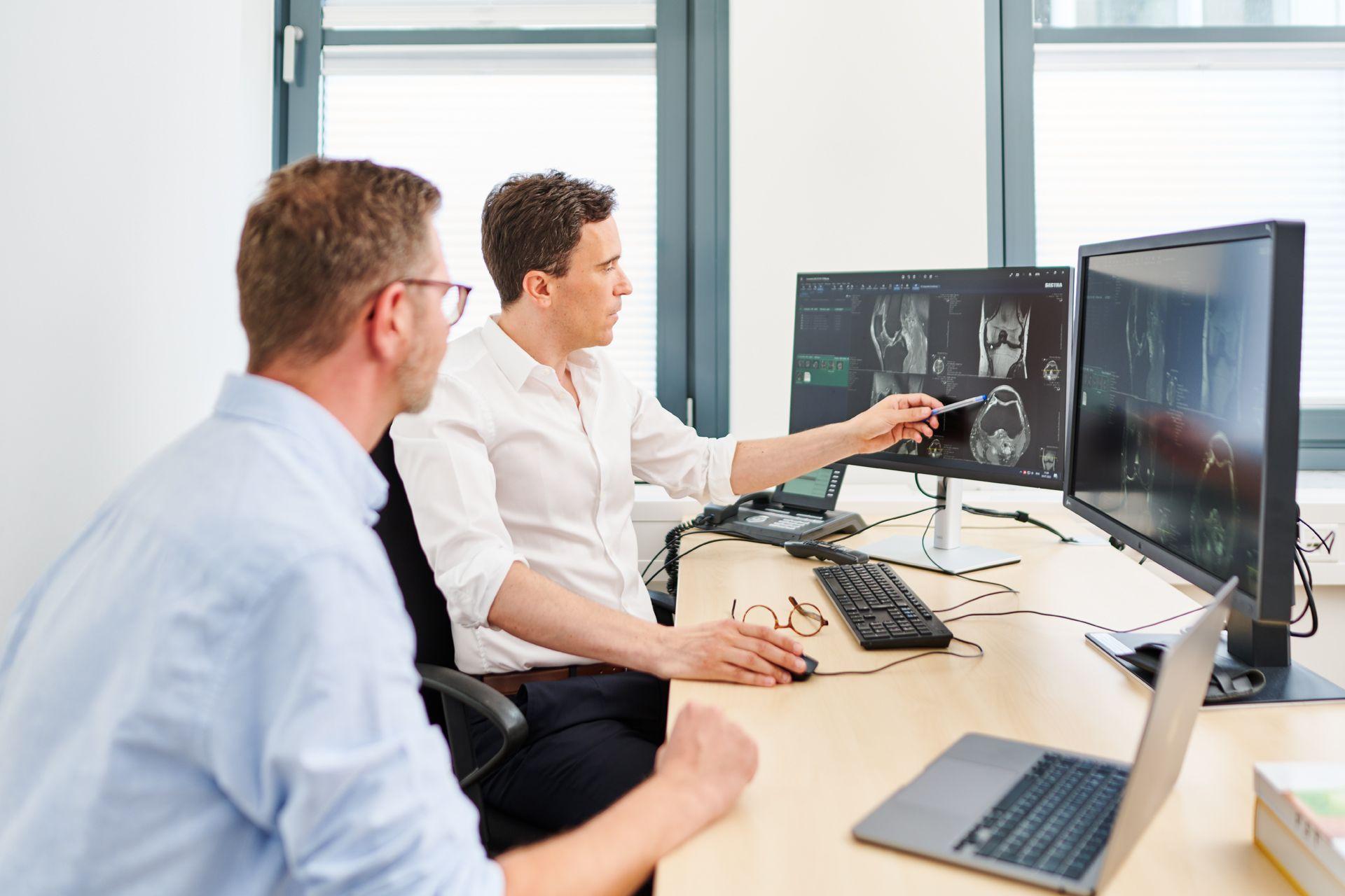 Prof. Dr. med. Florian Streitparth bespricht mit einem Patienten einen Befund.