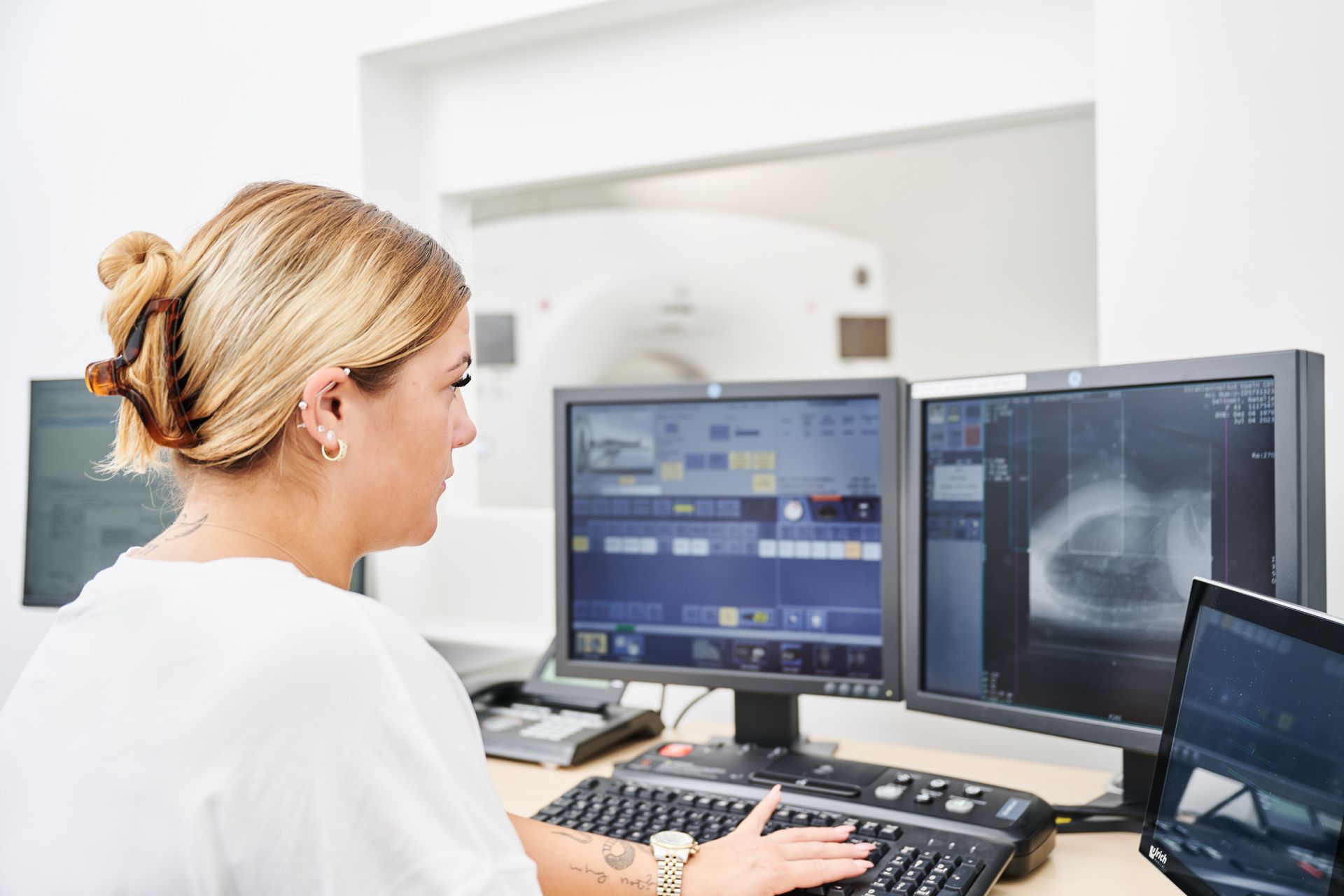 Medizinische Fachkraft sieht sich CT-Bilder auf einem Computer Bildschirm an.