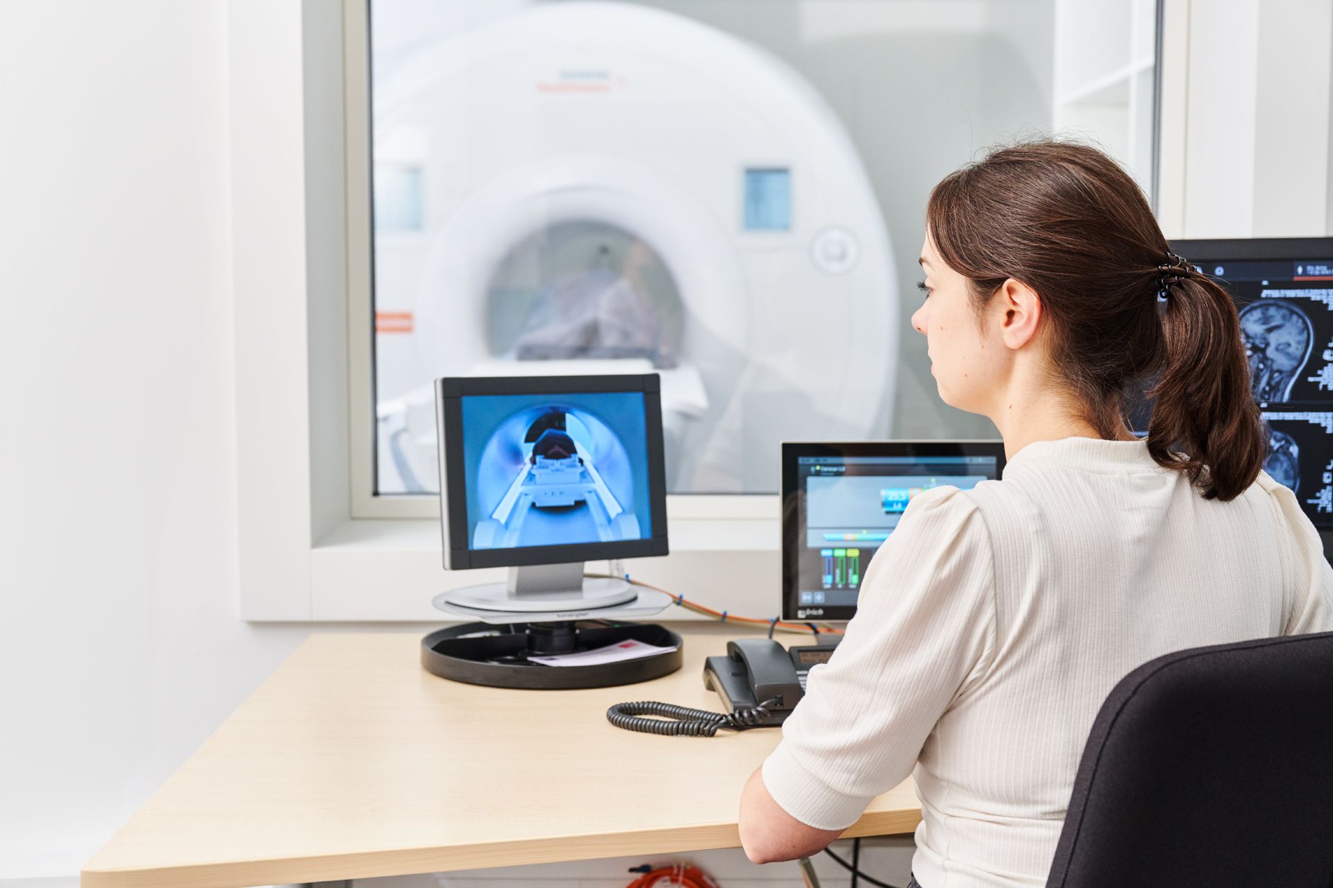 Medizinische Fachkraft sieht sich die MRT-Bilder auf einem Computer Bildschirm an.