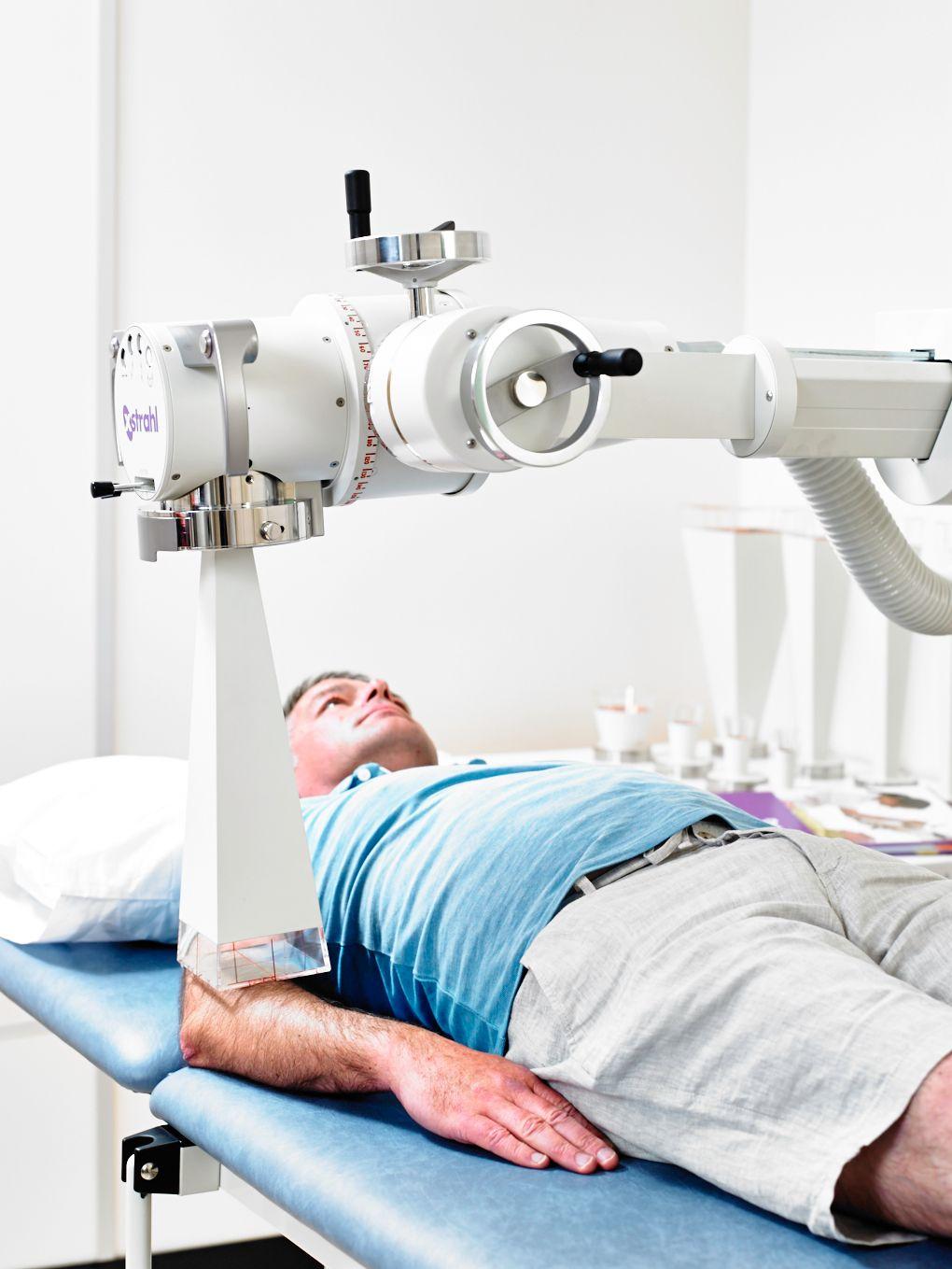 Patient bei der Orthovolt-Therapie am Ellenbogen.